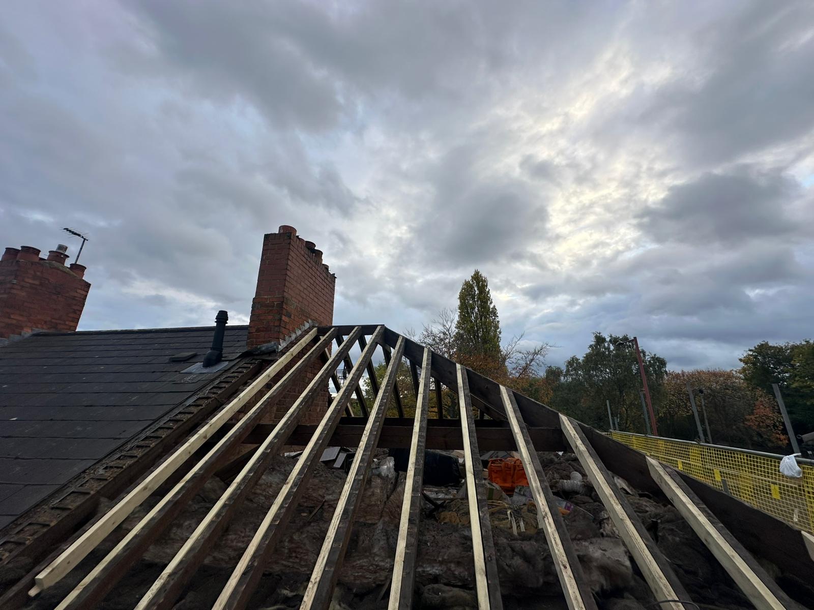 Storm-damaged pitched roof stripped back to rafters during an emergency roofing call-out