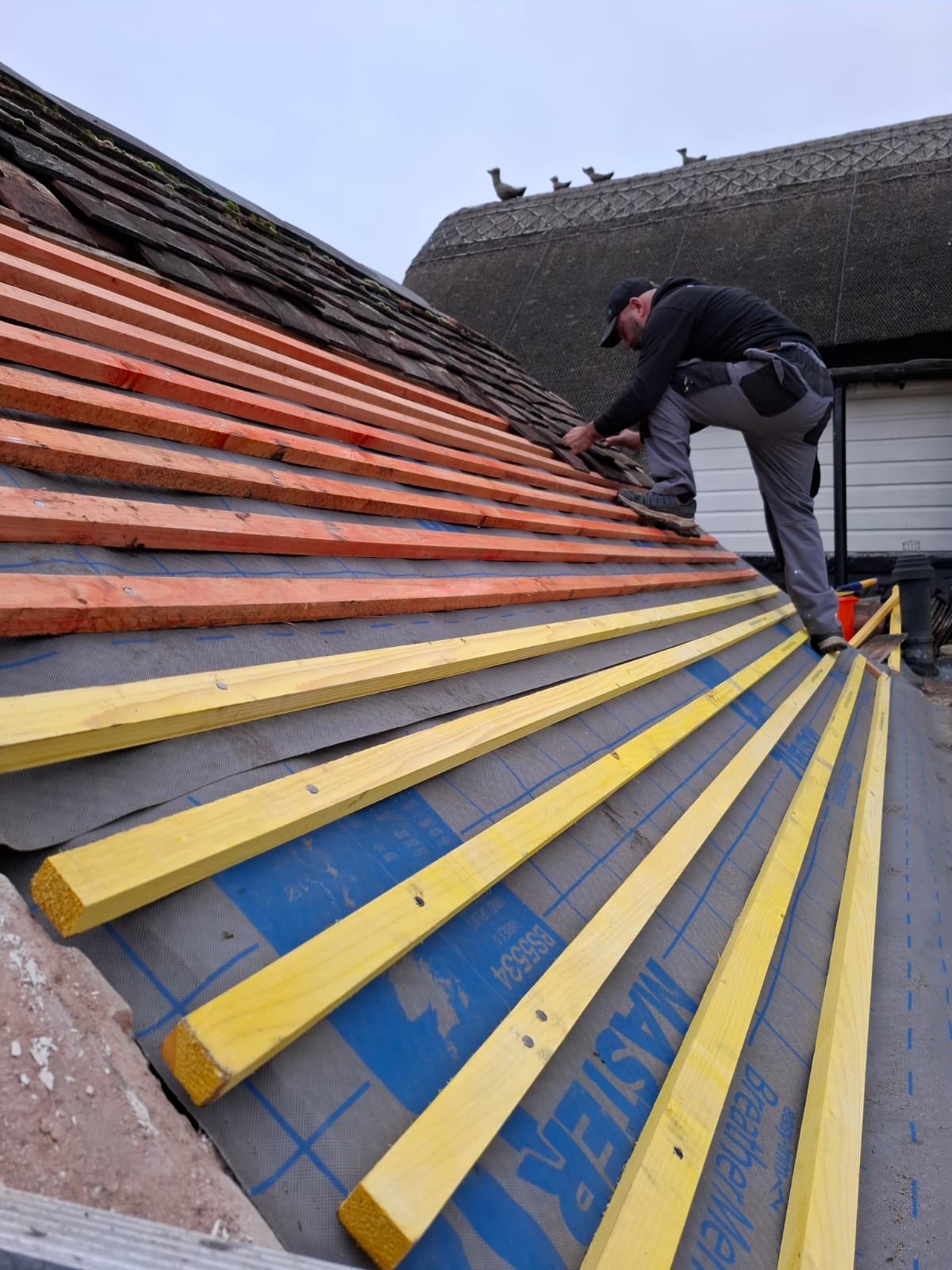 Treated softwood roof battens fixed over felt membrane on a pitched roof