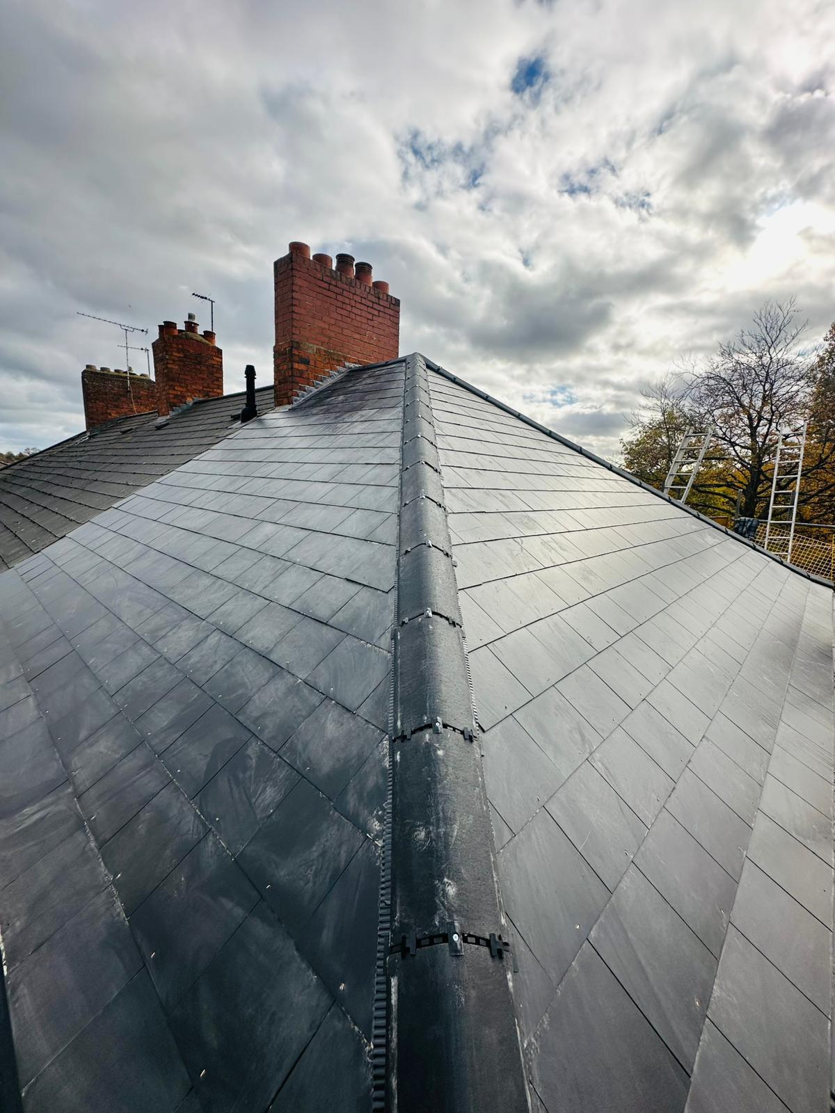 Newly installed natural slate hipped roof with lead ridge detail, full re-roof by UK Roofing and Improvements Ltd
