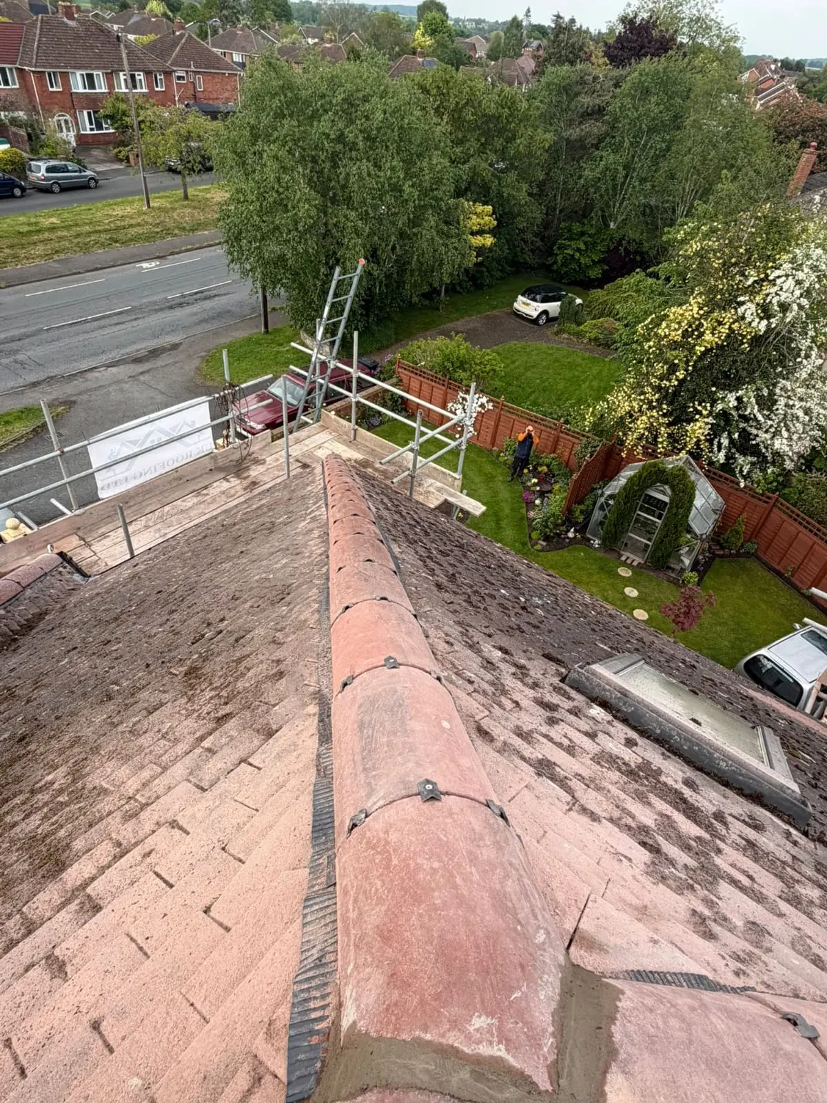 Moss and lichen covering a pitched tile roof in Worcestershire before soft-wash roof cleaning