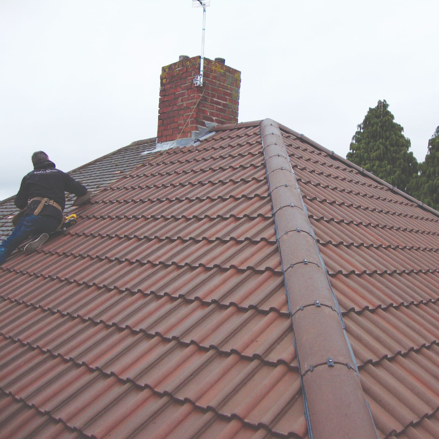 New red concrete tile hipped roof with repointed chimney stack