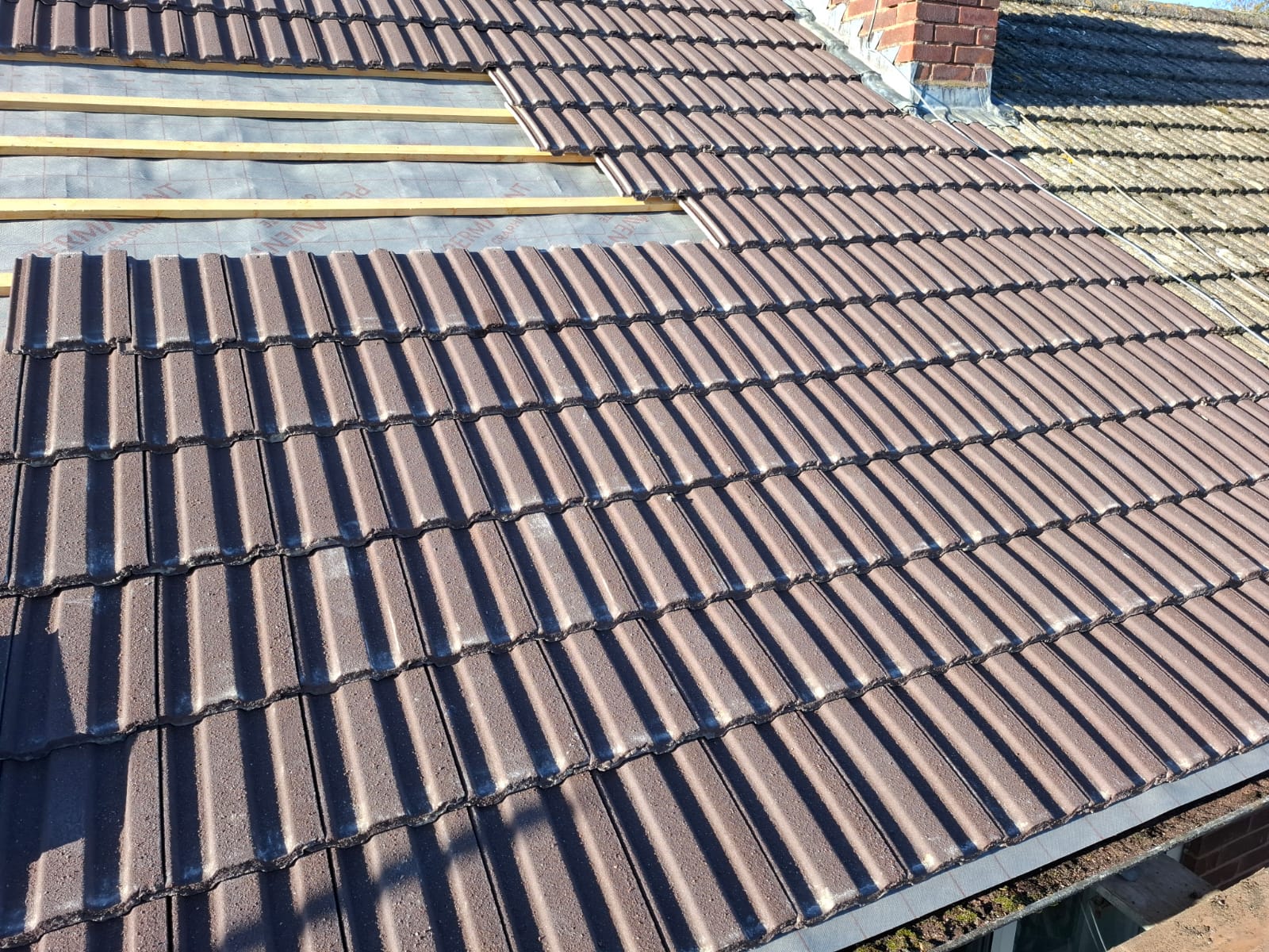 Concrete interlocking tile re-roof with new membrane and counter-battens
